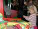 Child playing an arcade game with colorful machine and people in the background