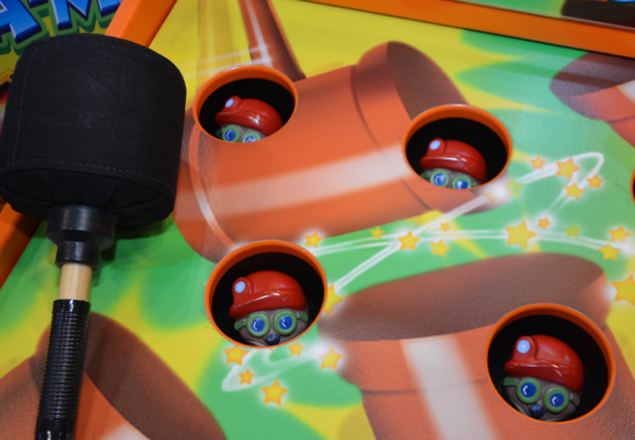 Toy gun with darts on a colorful game board