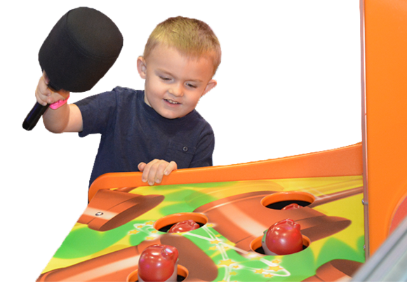 Child playing with a colorful game machine, holding a paddle.