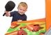Child playing with a colorful game machine, holding a paddle.