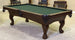 A traditional style pool table with arched cabinets, dentil holding side rails, and ball & claw legs in a dark finish, with green felt top and brown leather pockets.