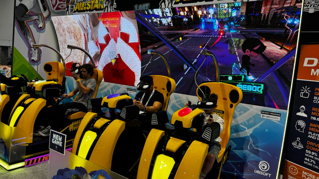 Simulator racing chairs in an arcade with video game displays on the wall.