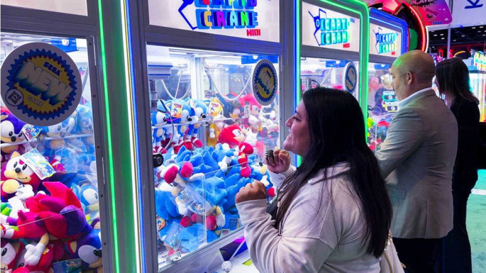 People playing claw machine games in an arcade setting