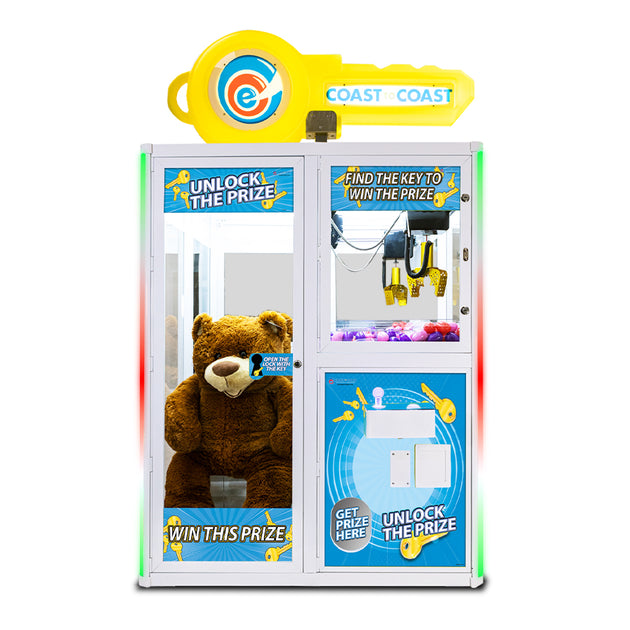 Prize claw machine with teddy bear prize inside, featuring Coast branding.