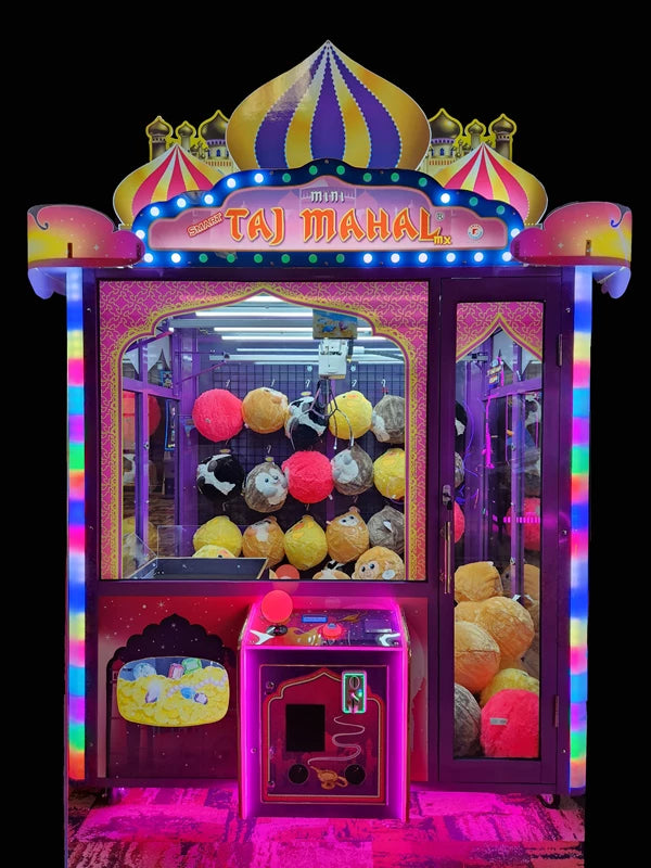 Colorful claw machine with 'Taj Mahal' branding on a dark background